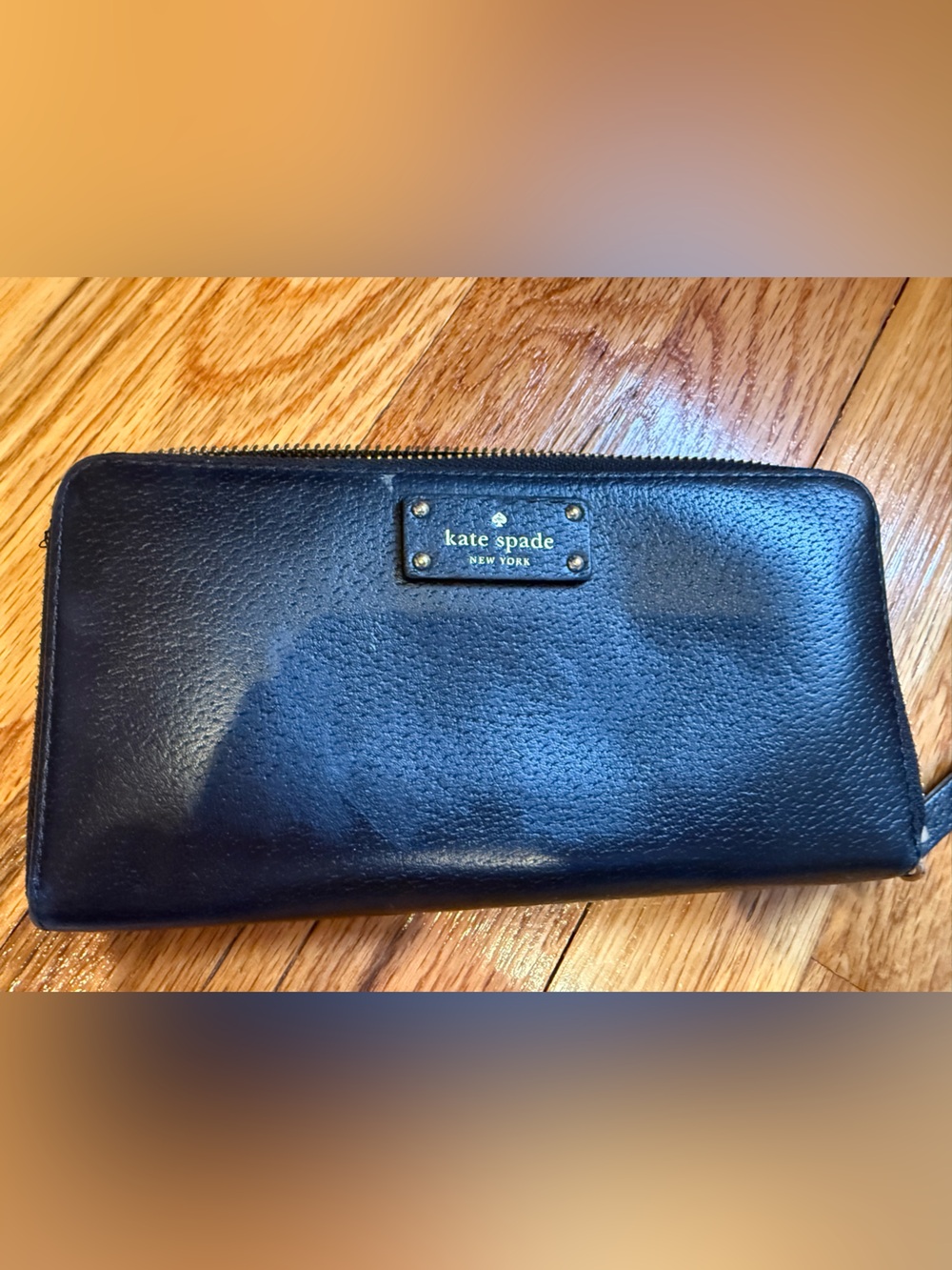 kate spade black zip-around pebble leather wallet with gold logo plate